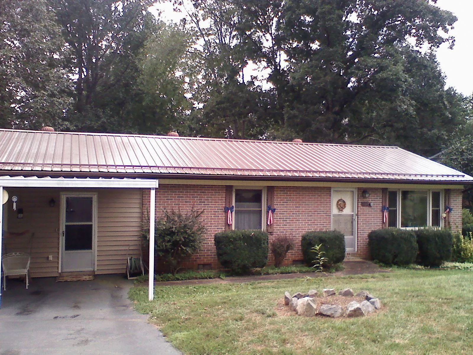 Bronze metal roof and carport on a brick ranch home — Roof Repair work by our crew in Saint Louis
